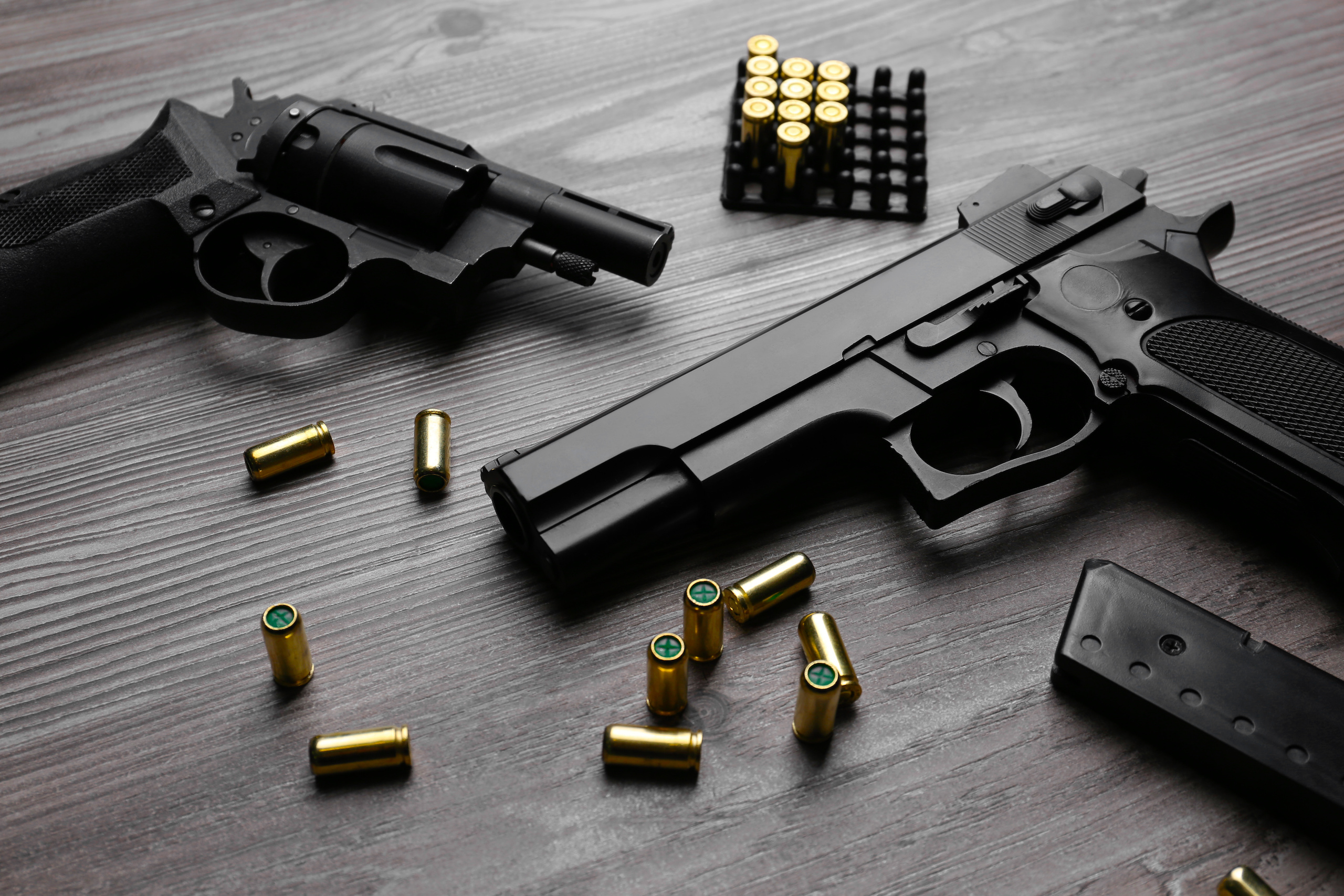 Pistols and bullets on wooden table. Professional guns